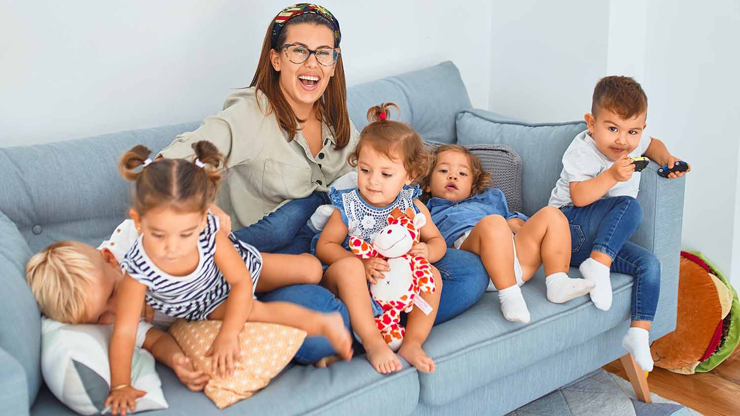 Mother and five children trying to stay still on a couch in their home