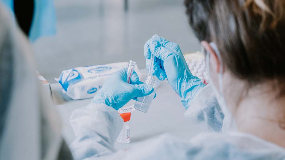 Looking over the should of a medical professional preparing injection with rubber gloves on