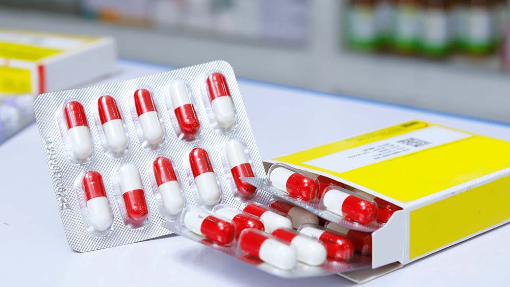 A yellow box of red and white pills in their plastic packaging