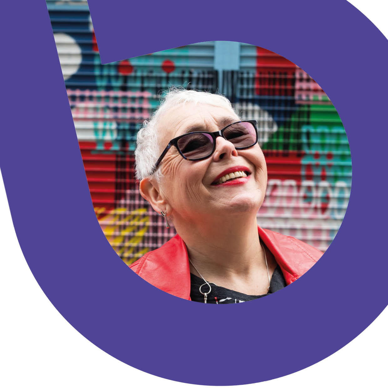 Woman with glasses and short white hair laughing