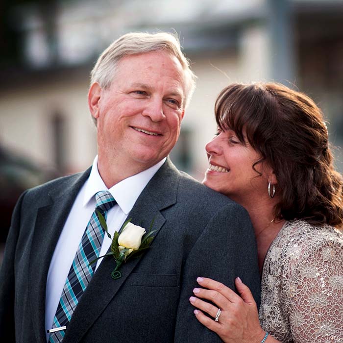Mature smiling man and women in formal suit and dress