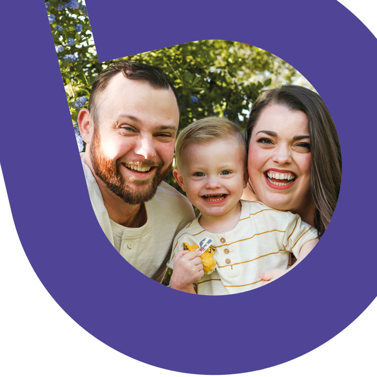 Mother and father with toddler son smiling broadly