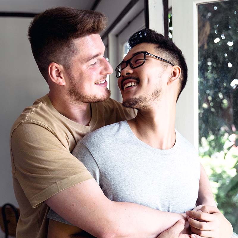 Two men hugging and smiling at each other
