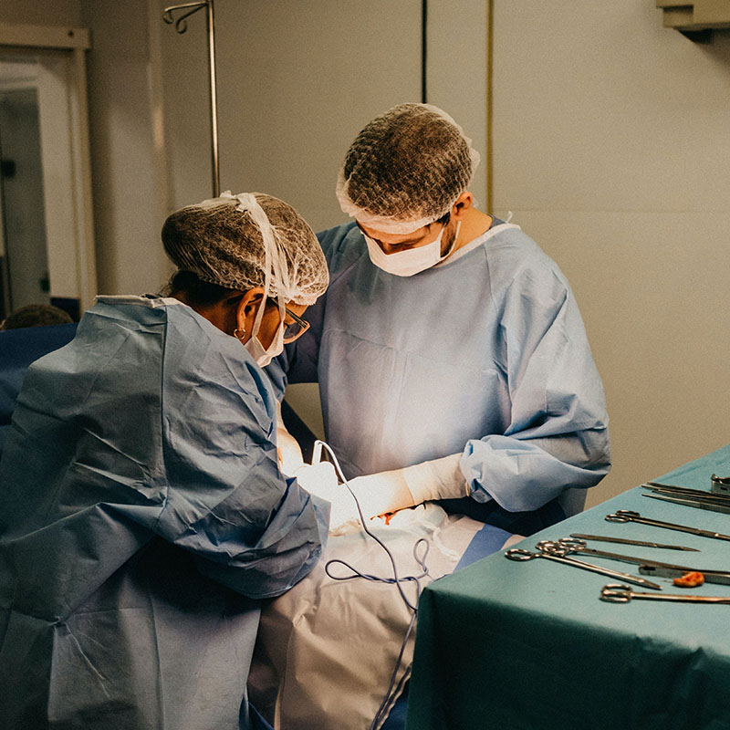 Two surgeons in an operating theatre treating a patient